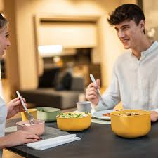 Woman enjoying food, meals in storage container, and food bowls on a table